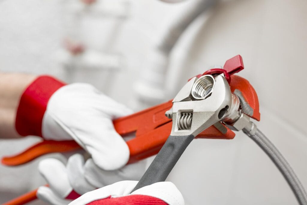 Plumber holding pipe wrenches for an emergency repair in Thornton