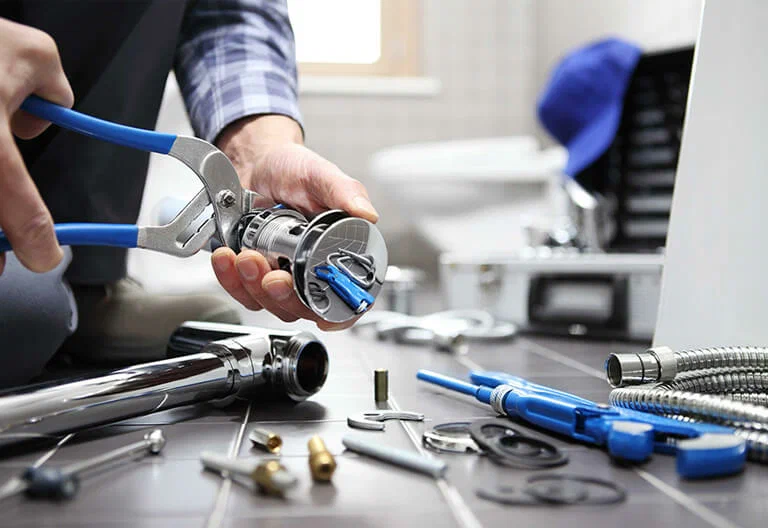 Technician repairing a plumbing fixture with professional tools in Thornton