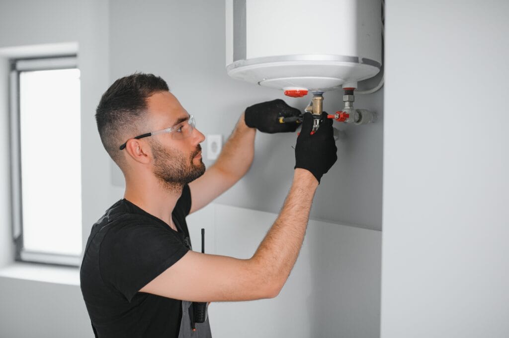 Technician performing water heater maintenance in Thornton