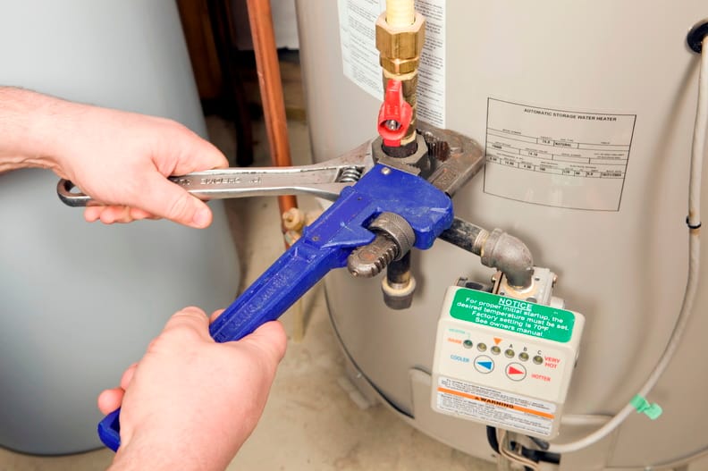 Plumber repairing a water heater valve in Thornton